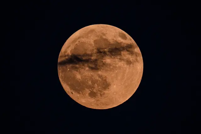 Një hënë me ngjyrë të kuqe në një qiell të zi.